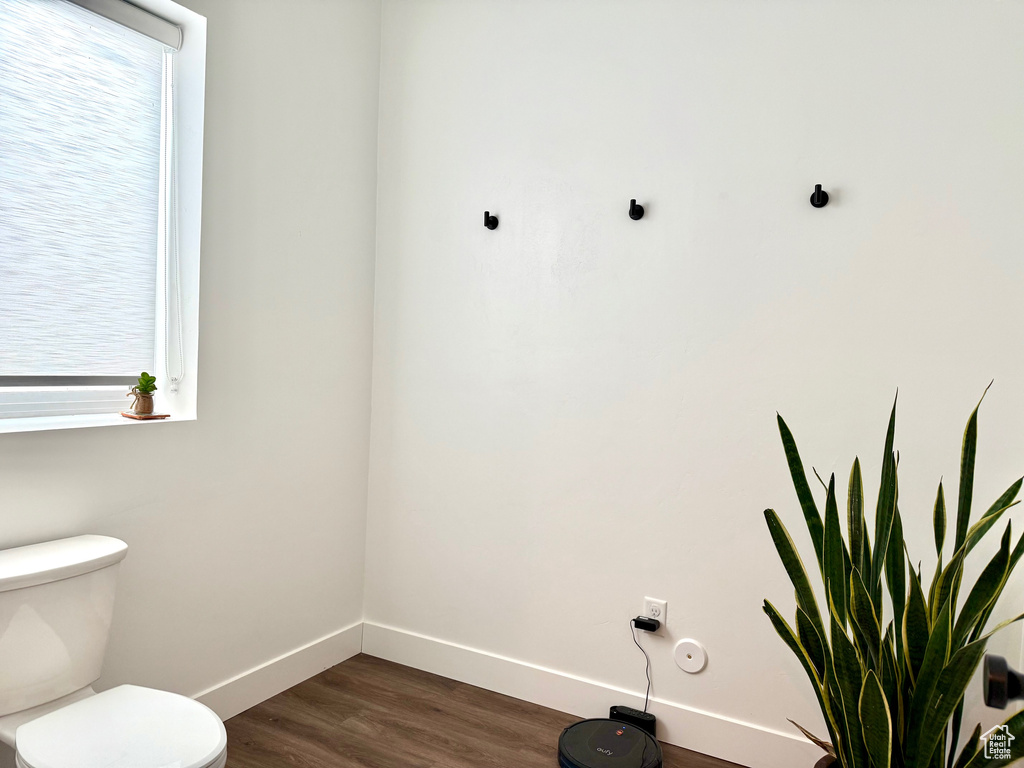 Bathroom with wood-type flooring, a wealth of natural light, and toilet