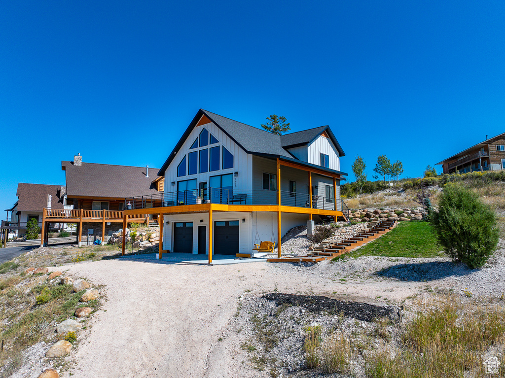 Back of property featuring a garage and a deck