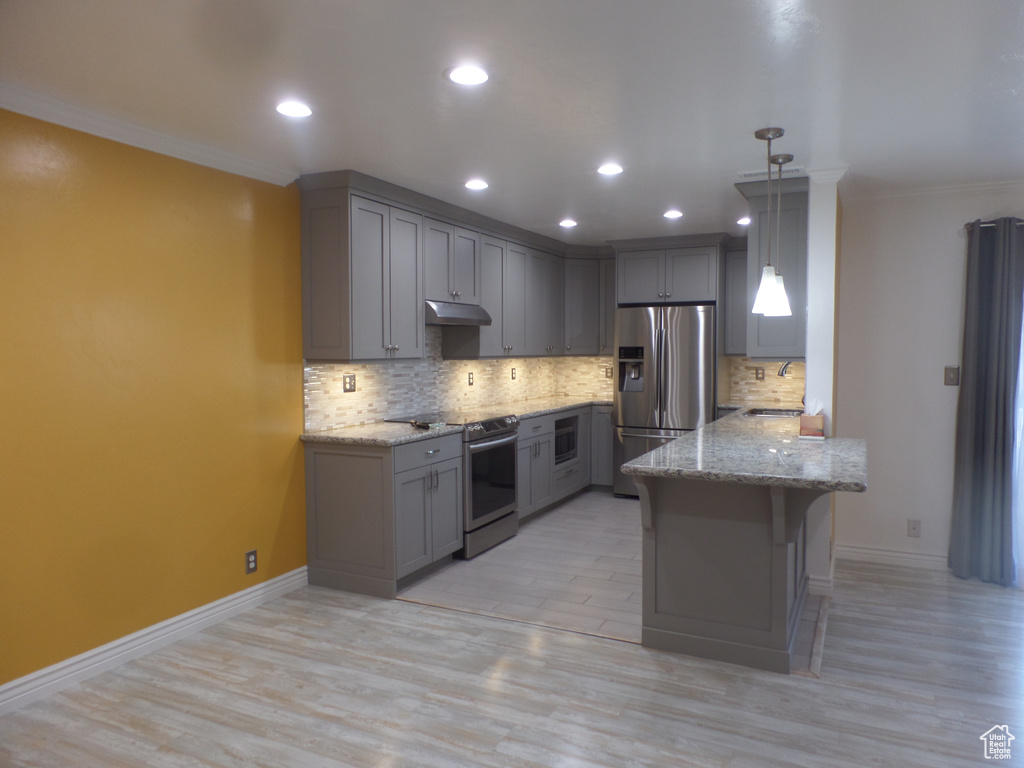 Kitchen with gray cabinets, appliances with stainless steel finishes, a kitchen breakfast bar, hanging light fixtures, and kitchen peninsula