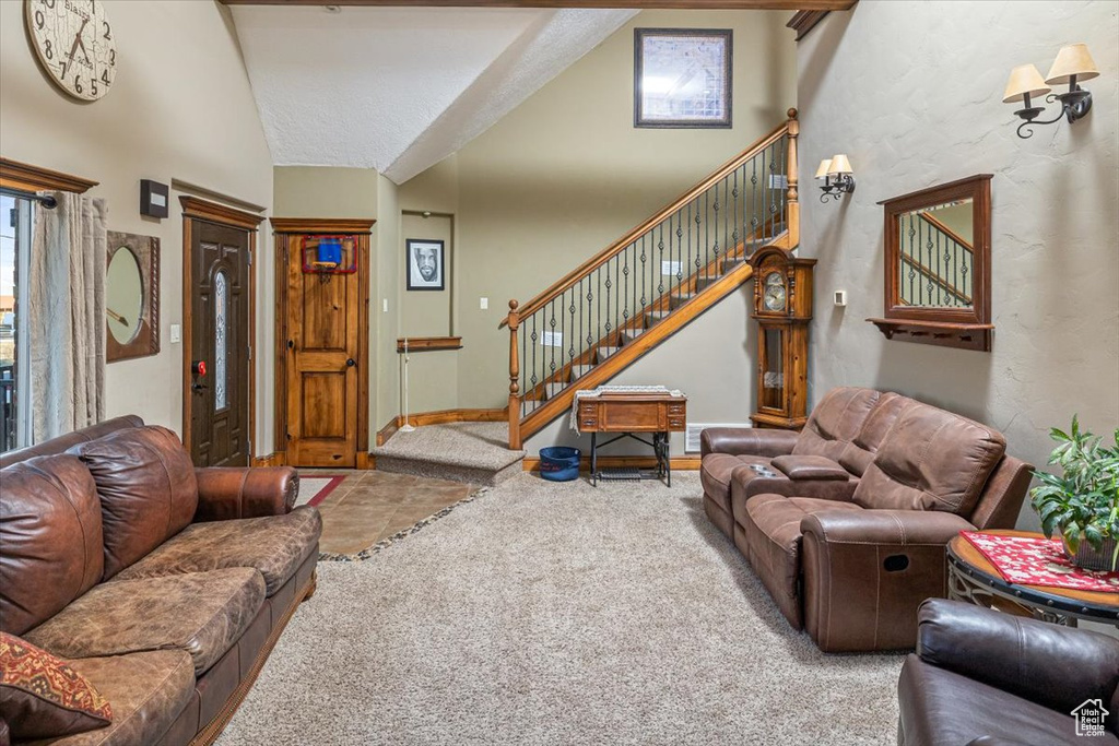 Carpeted living room featuring high vaulted ceiling