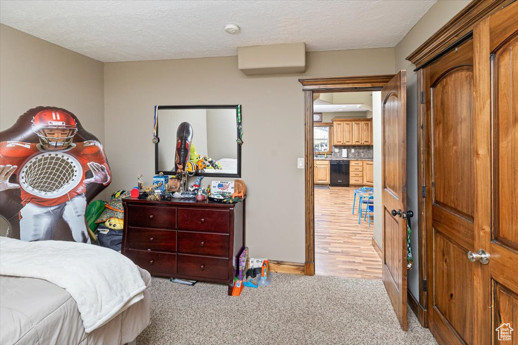 Bedroom featuring light colored carpet and a textured ceiling