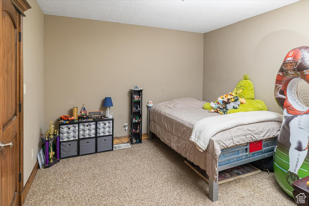 Carpeted bedroom with a textured ceiling