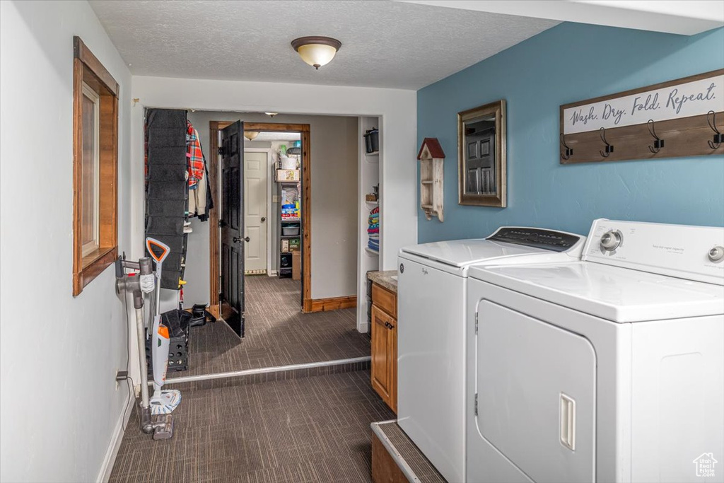 Laundry area with cabinets, a textured ceiling, and washer and clothes dryer