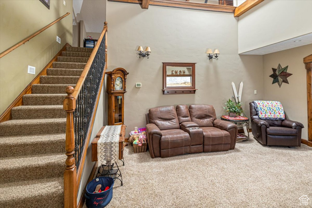 Carpeted living room with a towering ceiling