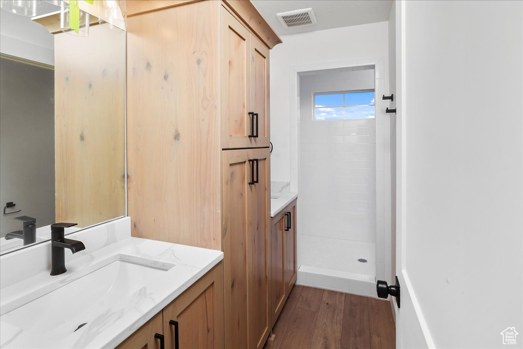 Bathroom with vanity, wood-type flooring, and walk in shower