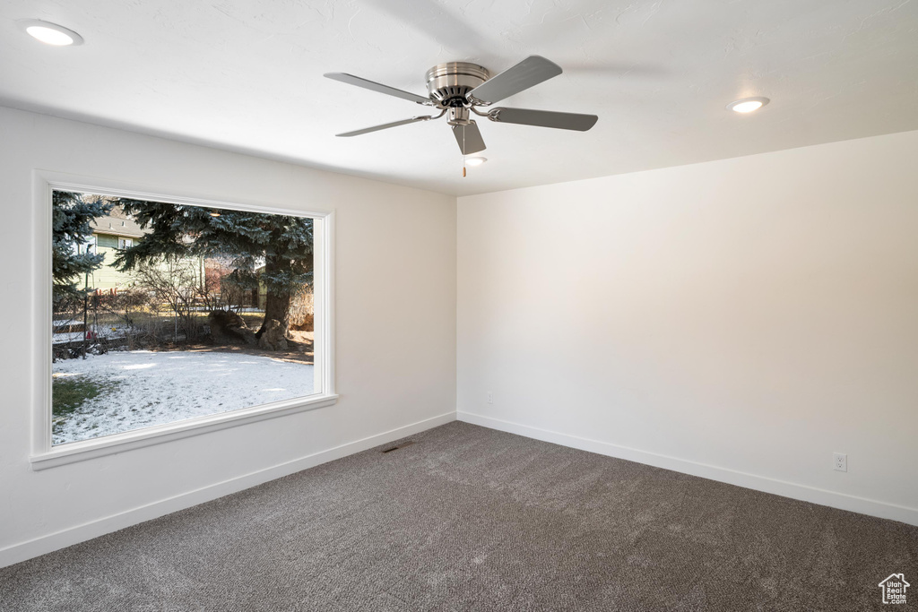 Carpeted spare room featuring ceiling fan