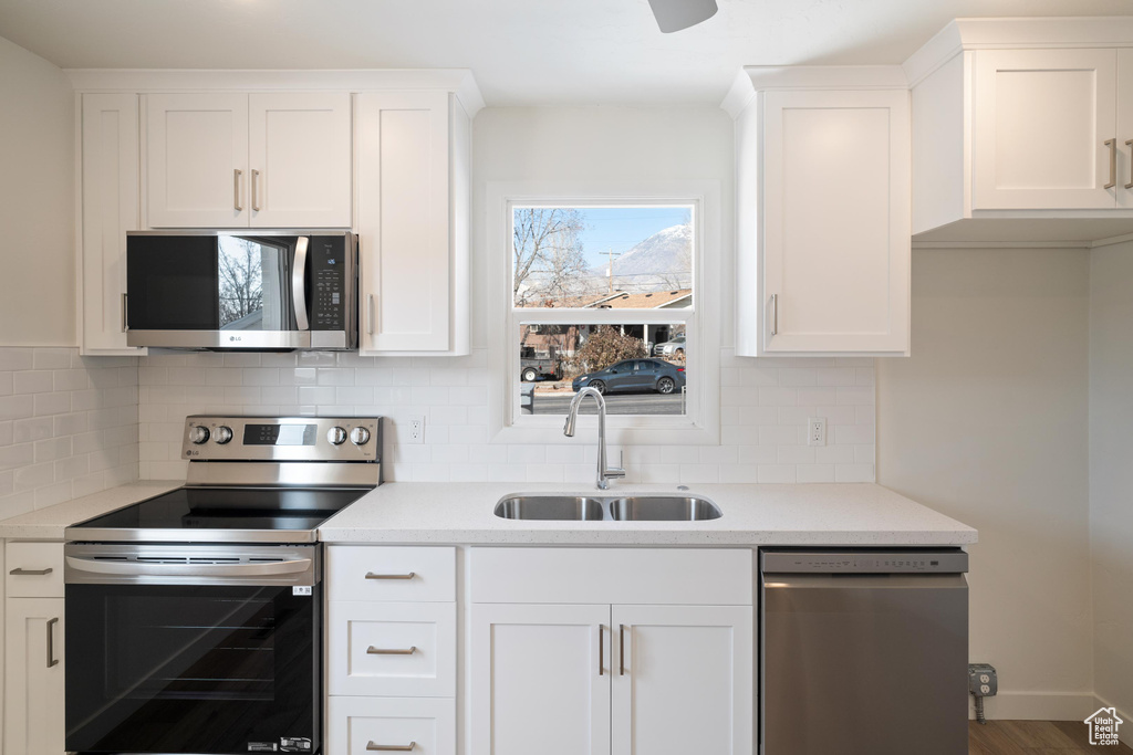 Kitchen featuring white cabinetry, appliances with stainless steel finishes, sink, and tasteful backsplash