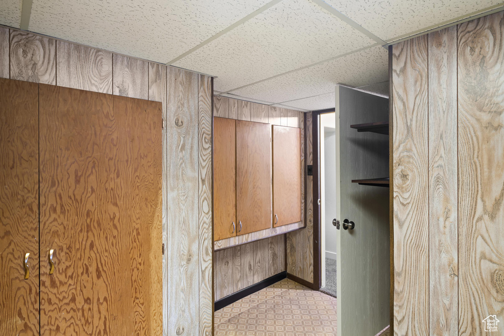 Interior space featuring a paneled ceiling and wood walls