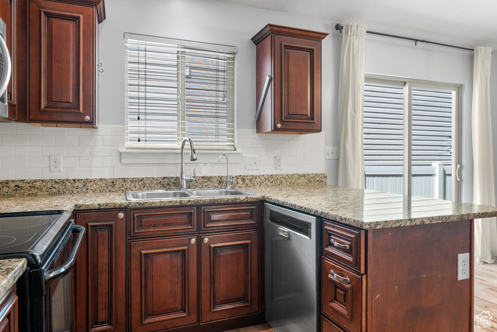 Kitchen featuring stainless steel appliances, a sink, tasteful backsplash, and a peninsula
