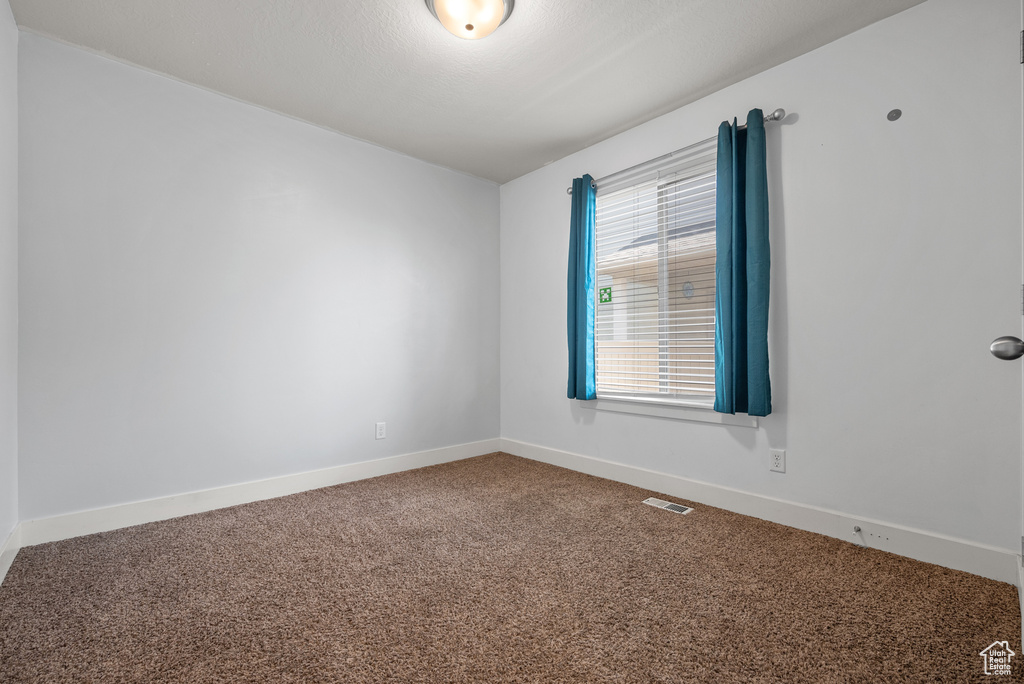 Carpeted spare room with baseboards