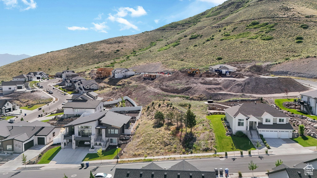 Aerial view of property and surrounding area with nearby suburban area and a mountain backdrop