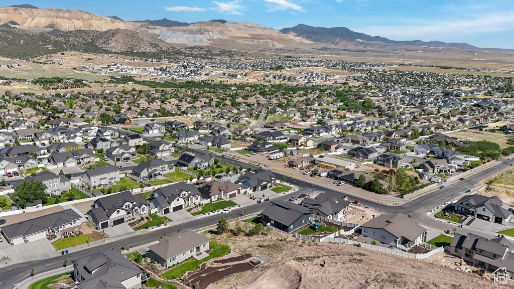Aerial view of property and surrounding area with a mountainous background and nearby suburban area