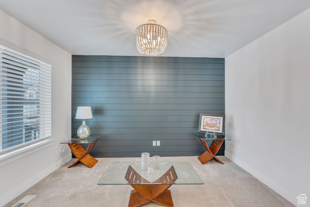 Sitting room with an inviting chandelier and carpet floors