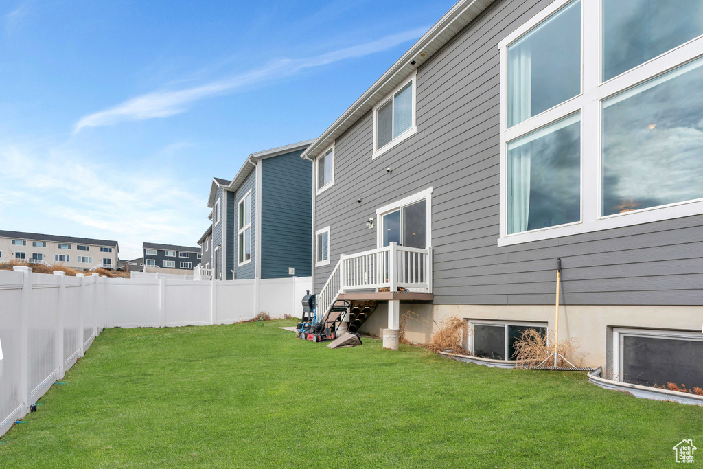 Rear view of property with a yard