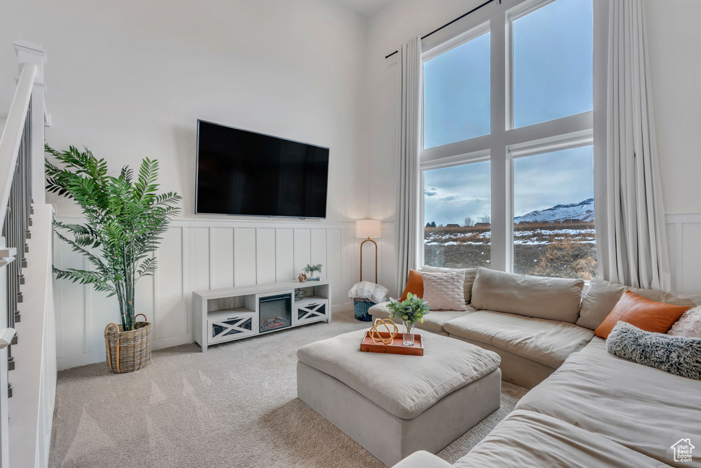 Carpeted living room with a towering ceiling