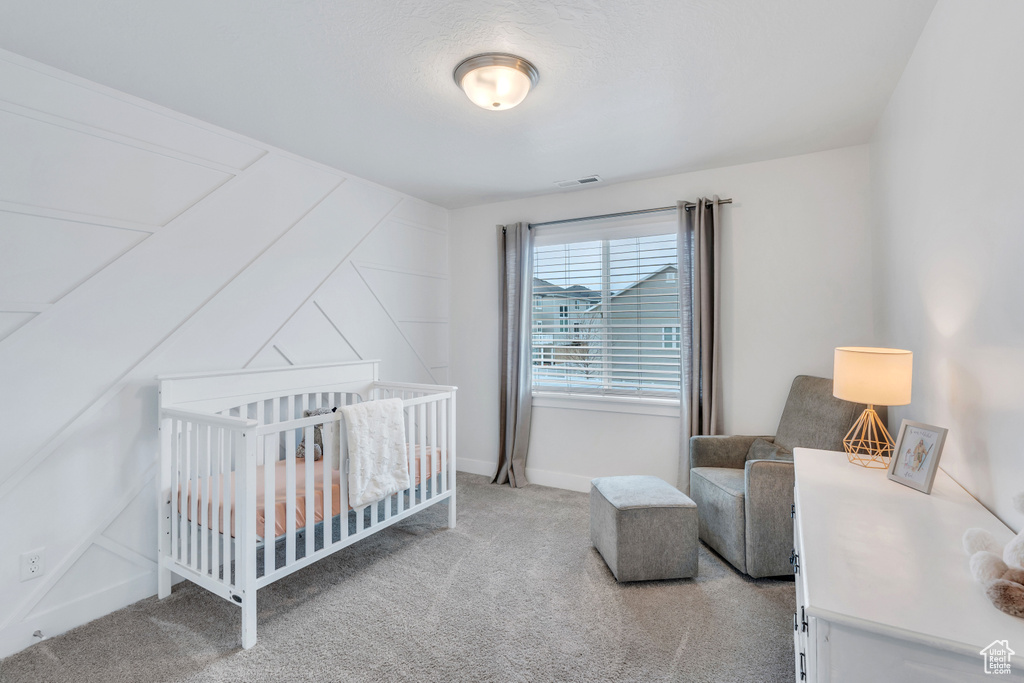 Bedroom with a crib and carpet floors