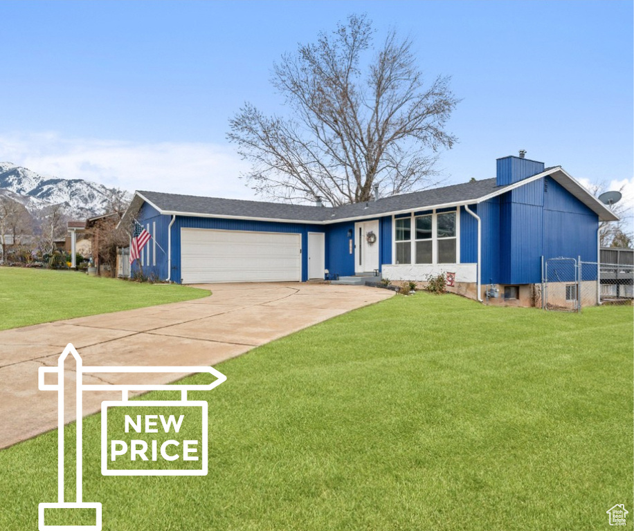 Single story home with fence, a front lawn, a garage, a mountain view, and driveway