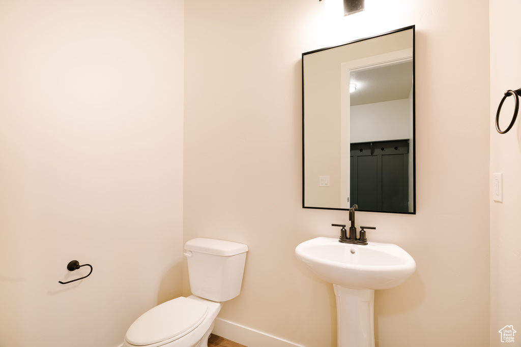 Half bath featuring baseboards and toilet