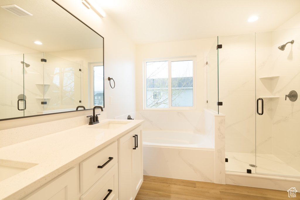 Bathroom with visible vents, a sink, a marble finish shower, and wood finished floors