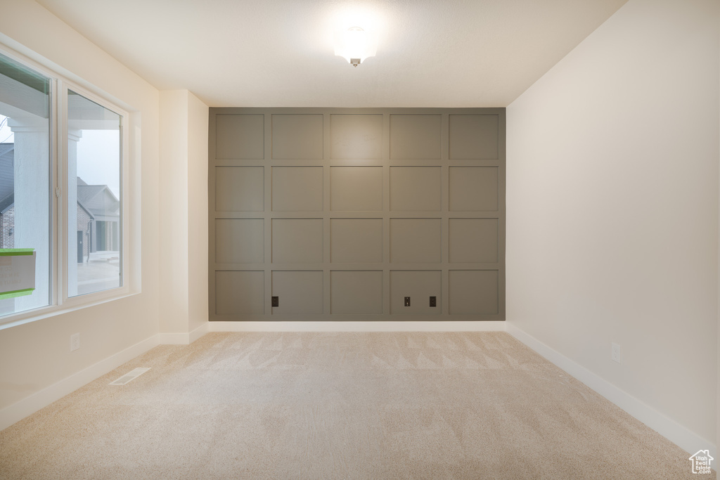 Empty room featuring baseboards, light carpet, and visible vents