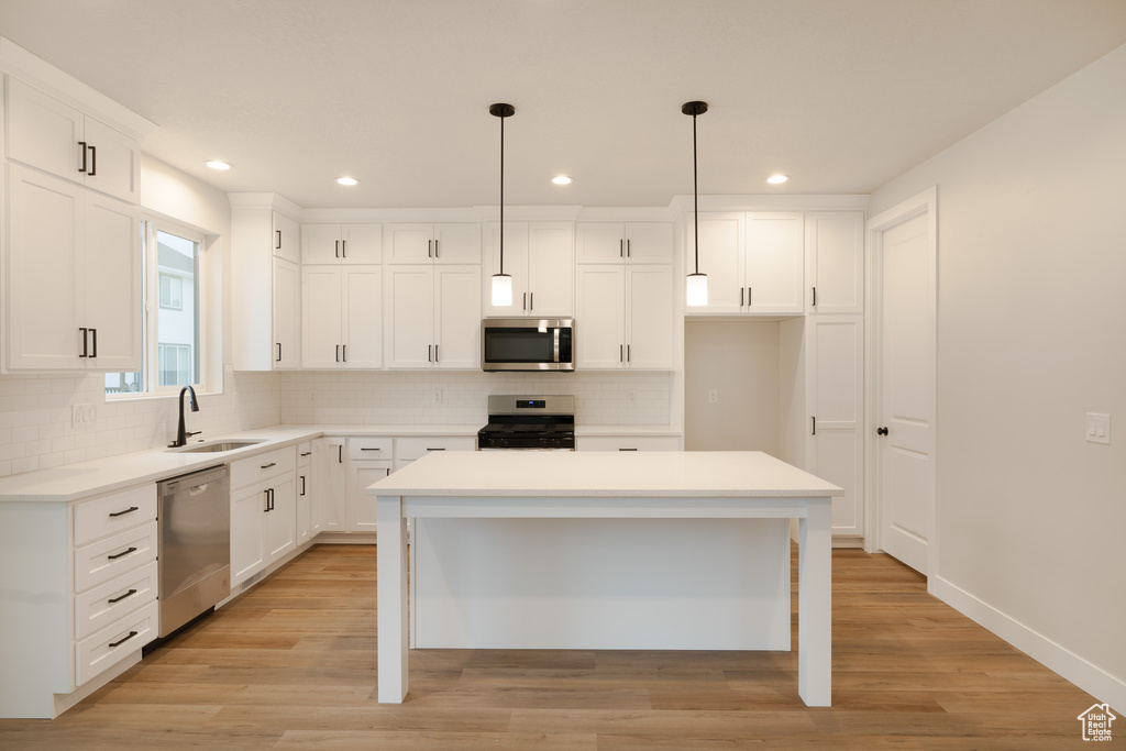 Kitchen with a sink, appliances with stainless steel finishes, tasteful backsplash, and recessed lighting