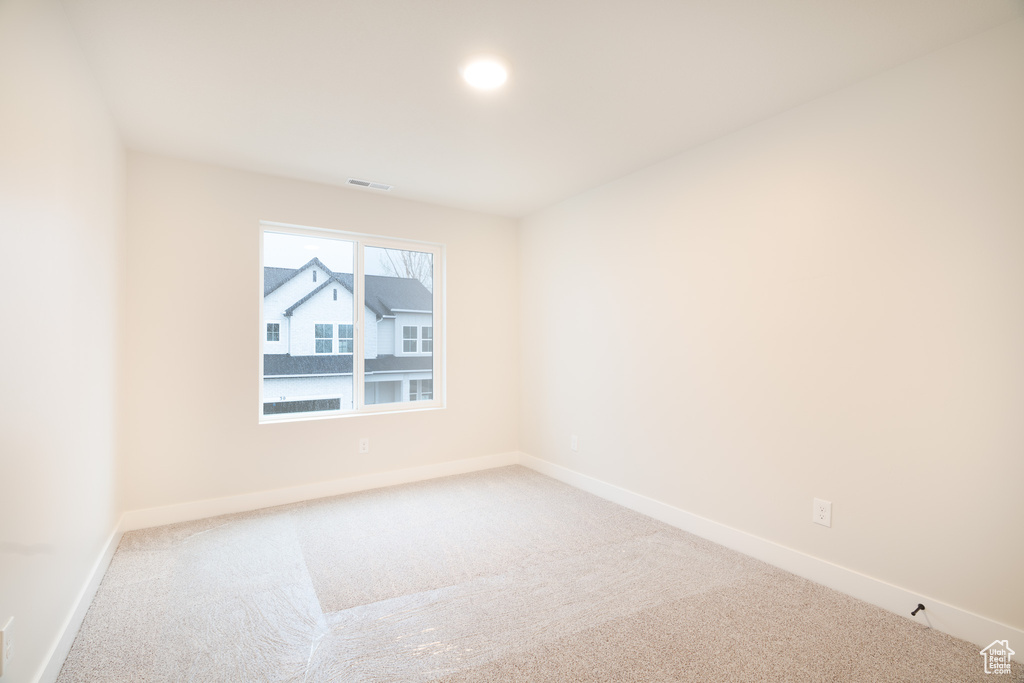 Carpeted spare room with baseboards and visible vents