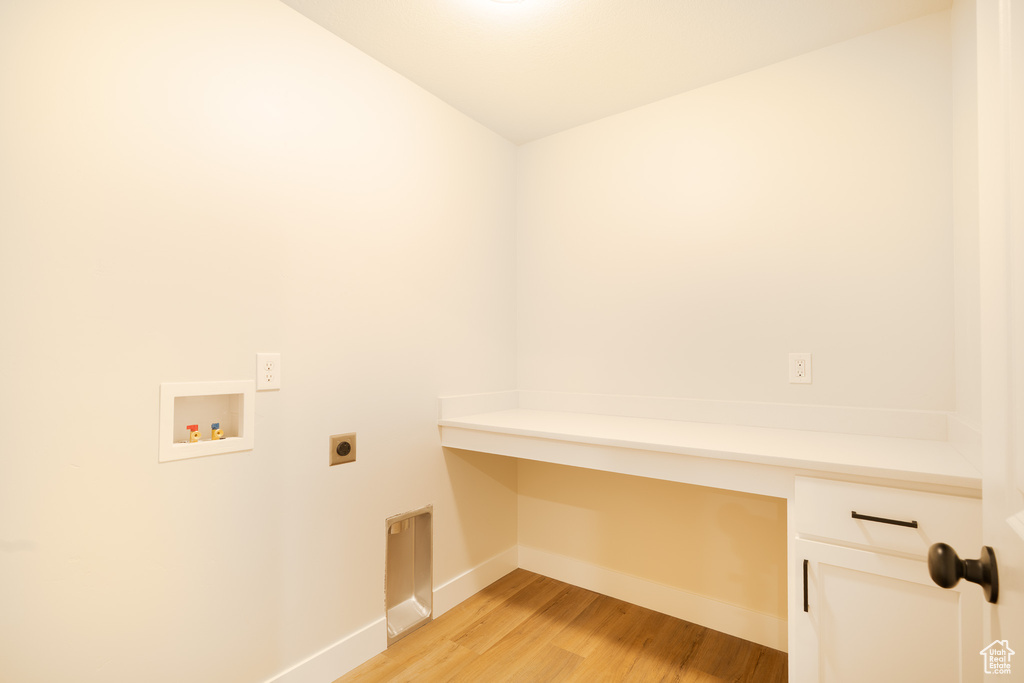 Washroom with light wood-style floors, hookup for a washing machine, baseboards, cabinet space, and hookup for an electric dryer