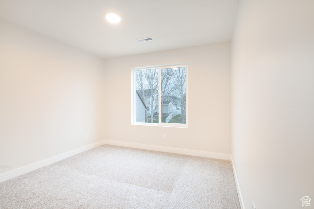 Empty room featuring recessed lighting, baseboards, visible vents, and light carpet