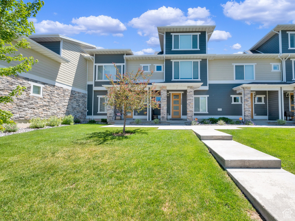 View of front of home featuring a front yard and stone siding