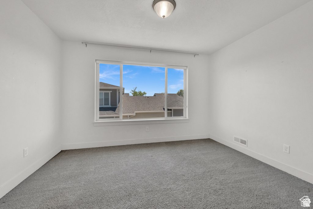 Carpeted empty room featuring baseboards