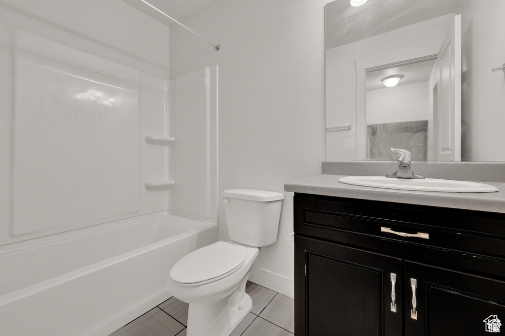 Full bath featuring vanity, bathing tub / shower combination, and tile patterned flooring