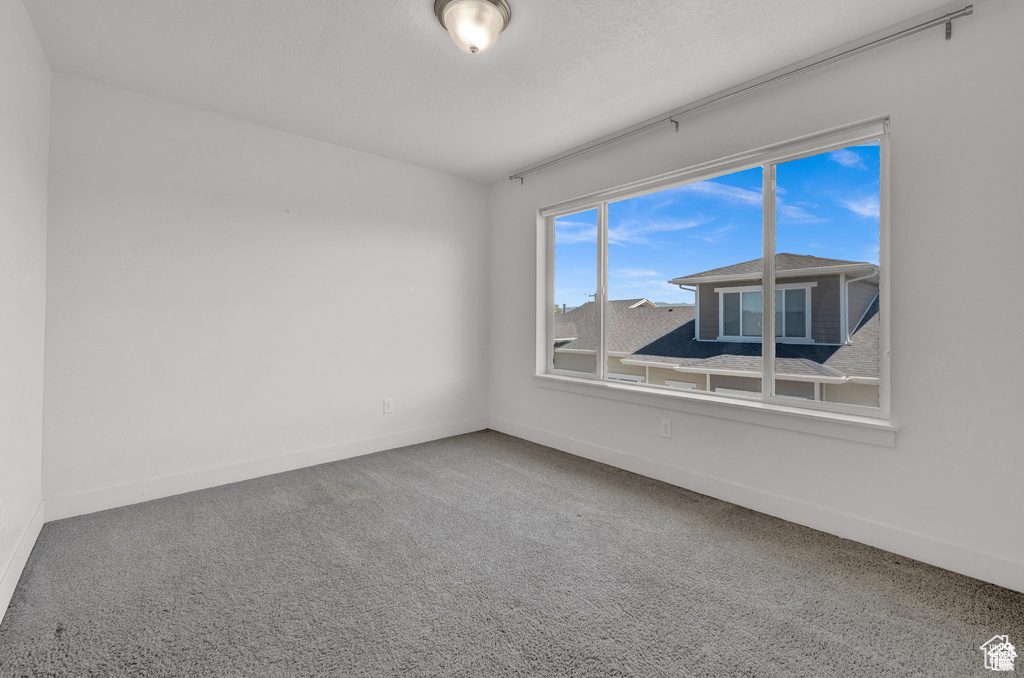 Spare room with baseboards and carpet