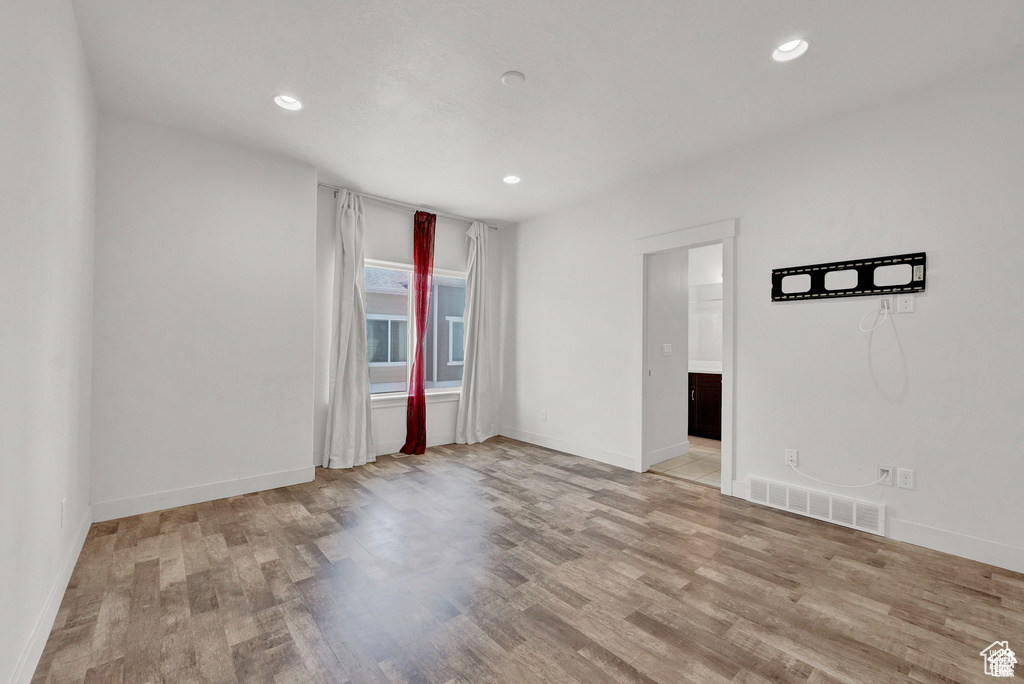 Spare room with wood finished floors and recessed lighting