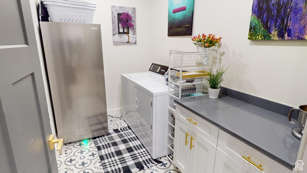 Washroom with cabinets, light tile patterned floors, and independent washer and dryer