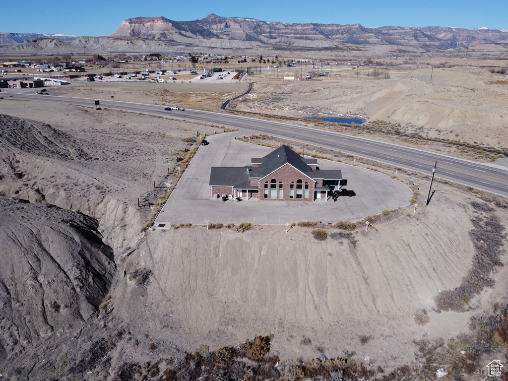 Aerial view of property and surrounding area featuring a mountain backdrop