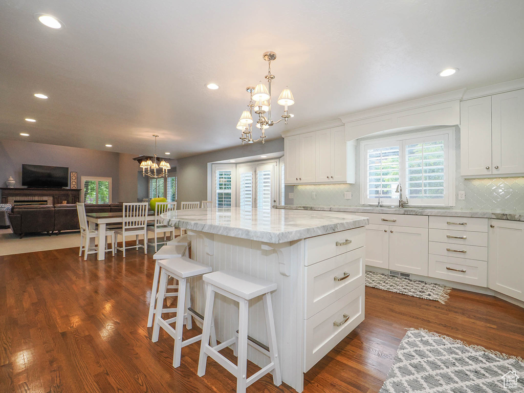 Kitchen featuring white cabinetry, a kitchen island, and decorative light fixtures