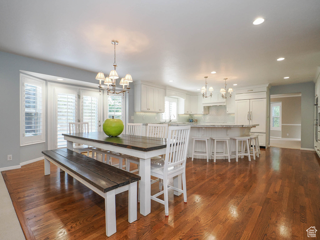 Dining area featuring sink, dark hardwood / wood-style floors, and a chandelier