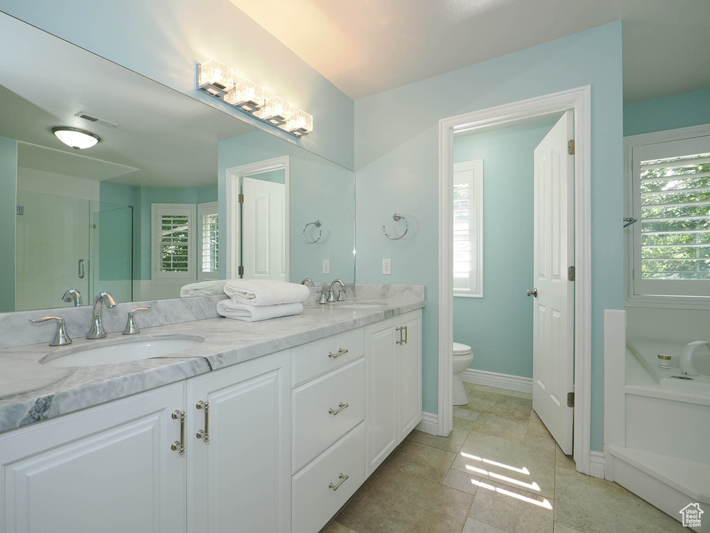 Bathroom with a shower with door, vanity, and toilet
