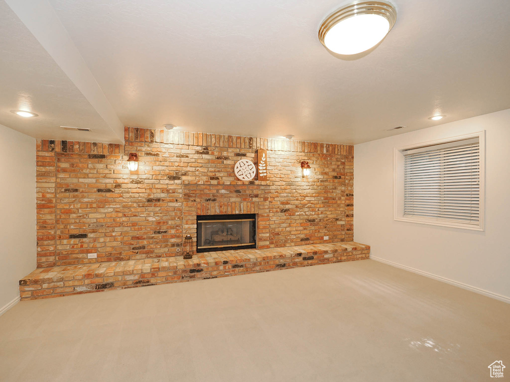 Interior space featuring brick wall, carpet flooring, and a brick fireplace