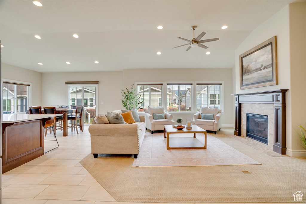 Living room with vaulted ceiling, recessed lighting, a ceiling fan, a fireplace, and light tile patterned floors
