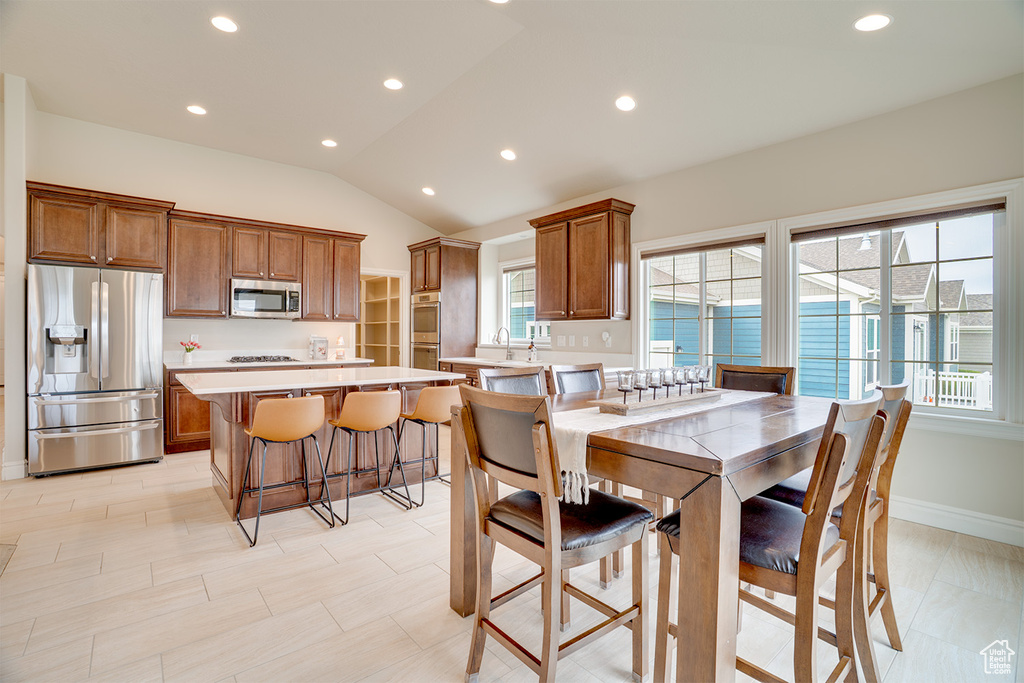 Dining area featuring vaulted ceiling, baseboards, a wealth of natural light, and recessed lighting