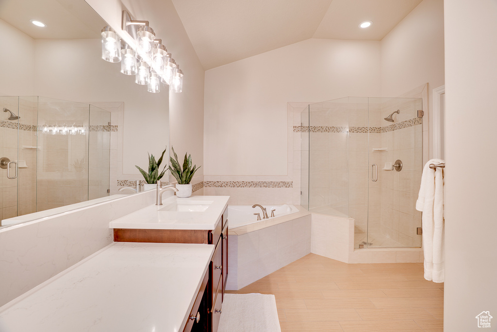 Bathroom with a garden tub, a stall shower, vanity, lofted ceiling, and recessed lighting