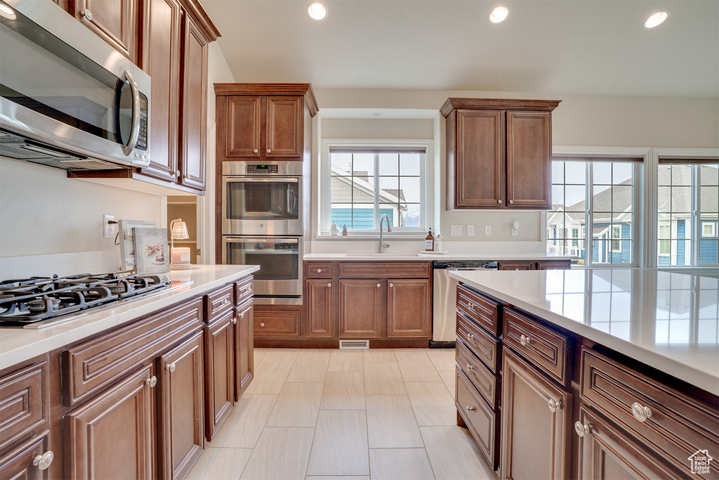 Kitchen featuring recessed lighting, appliances with stainless steel finishes, a sink, and light countertops