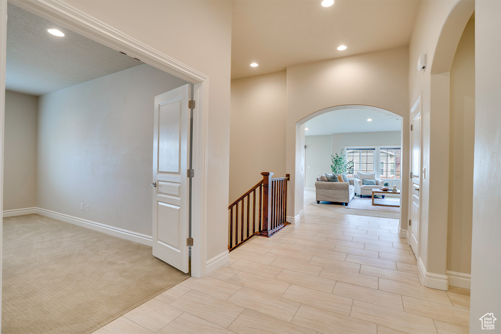 Corridor featuring arched walkways, baseboards, and recessed lighting