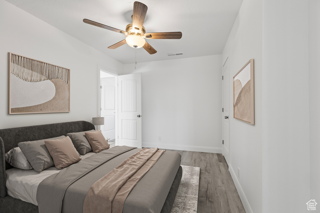 Bedroom with wood finished floors, baseboards, and ceiling fan