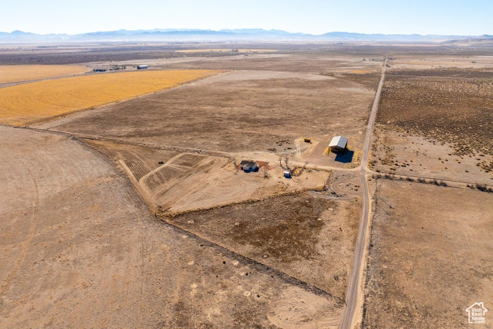 Aerial view of property and surrounding area with rural landscape, a desert landscape, and mountains