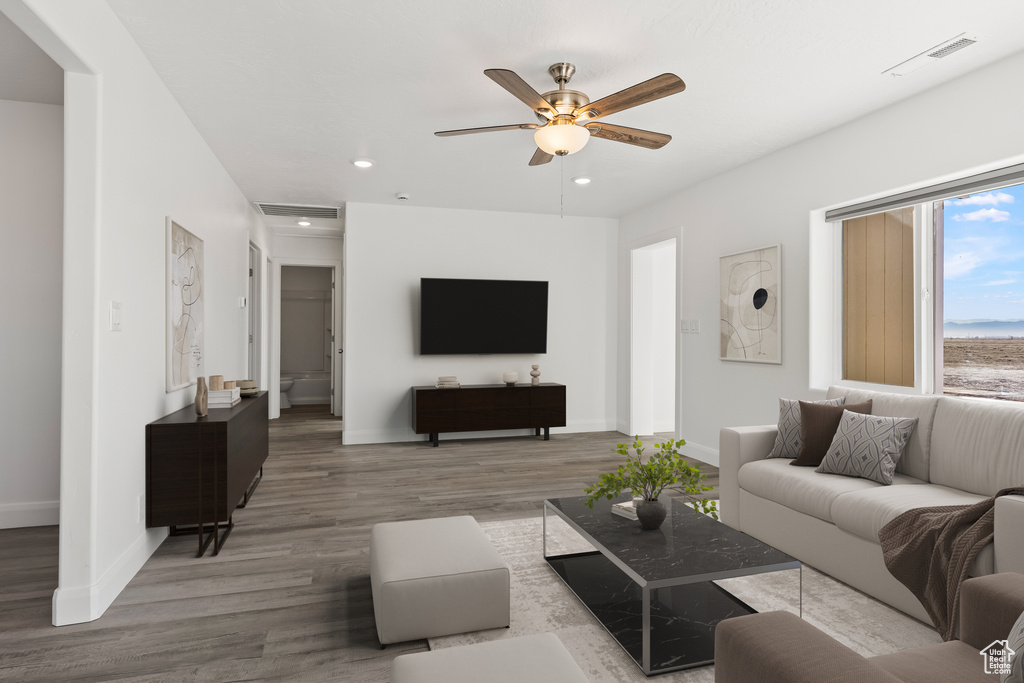 Living area featuring a ceiling fan, wood finished floors, baseboards, and recessed lighting