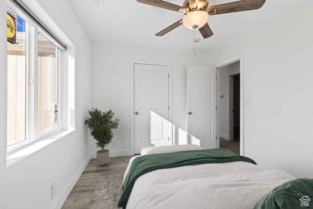 Bedroom featuring light wood-style flooring, baseboards, and ceiling fan