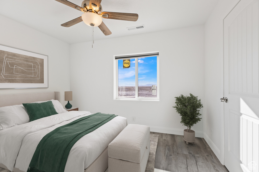 Bedroom featuring wood finished floors, baseboards, and a ceiling fan