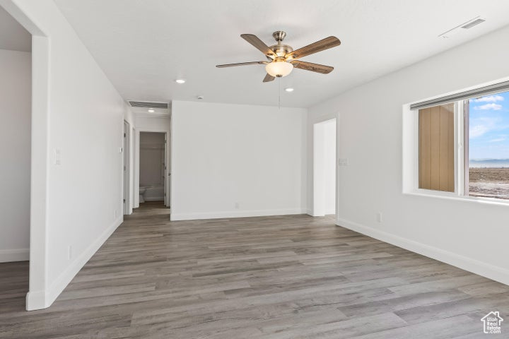 Spare room with ceiling fan, recessed lighting, baseboards, and wood finished floors